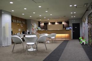 una zona di attesa di un negozio con sedie e bancone di Hotel Green City a Sendai