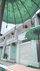 a building with a green ceiling and an umbrella at Kaktus Boutique Apartments Bali - ADULTS RETREAT in Legian
