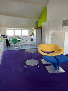 um quarto com uma cadeira amarela e uma cozinha em PetitGrandeur em Maastricht