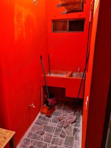 een rode badkamer met een wastafel en een dweil bij Casa Naranja in Granada