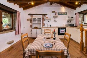 a dining room with a table and a kitchen at Casa rural La alemana in Liérganes