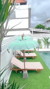 - une terrasse avec 2 chaises et un parasol dans un bâtiment dans l'établissement Kaktus Boutique Apartments Bali - ADULTS RETREAT, à Legian