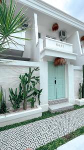 勒吉安的住宿－Kaktus Boutique Apartments Bali - ADULTS RETREAT，绿门和一些植物的房子