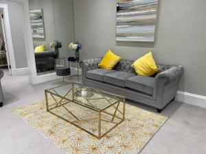 a living room with a couch and a glass table at Central Park Apartments in London