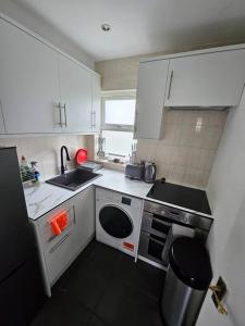 a small kitchen with a sink and a microwave at Nice and Cosy Studio Flat in Carshalton