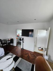 a living room with a room with a table and a tv at Nice and Cosy Studio Flat in Carshalton