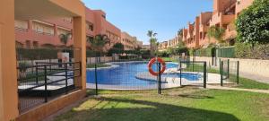 einem Pool in der Mitte eines Apartmentkomplexes in der Unterkunft Homes of Spain, Apartamentos Paraíso, Ed Palmerston, Atico O, Suite con Piscina Privada en solárium, vistas al mar, a 50 m de la playa, WIFI in Playas de Vera