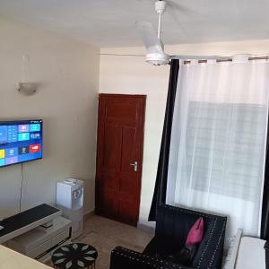 a living room with a brown door and a chair at Avril's studio apartment in Mombasa