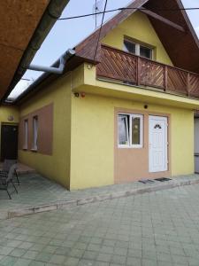 ein gelbes Haus mit einer Terrasse darüber in der Unterkunft Apartmány Drážovce in Nitra