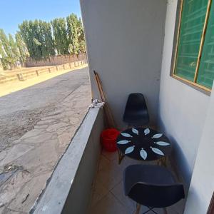 a room with two chairs and a table on a balcony at Avril's studio apartment in Mombasa
