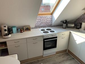 a small kitchen with a stove and a window at Best-Preis Ferienwohnung mit Netflix, Self-Check-In, eBike Ladestation im Fahrradraum, WLAN - direkt am Elberadweg im Herzen von Wittenberge in Wittenberge