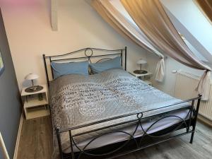 a bedroom with a metal bed with blue pillows at Best-Preis Ferienwohnung mit Netflix, Self-Check-In, eBike Ladestation im Fahrradraum, WLAN - direkt am Elberadweg im Herzen von Wittenberge in Wittenberge