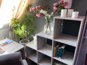 uma estante de livros com um vaso de flores e livros em Best-Preis Ferienwohnung mit Netflix, Self-Check-In, eBike Ladestation im Fahrradraum, WLAN - direkt am Elberadweg im Herzen von Wittenberge em Wittenberge