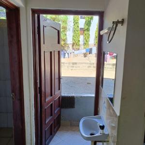 an open door to a bathroom with a sink at Avril's studio apartment in Mombasa