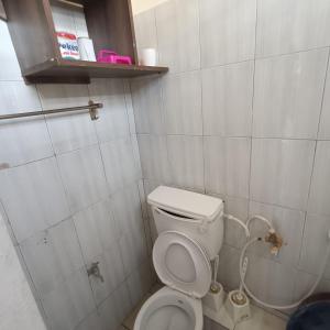 a small bathroom with a toilet and a shower at Avril's studio apartment in Mombasa