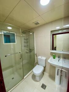 a bathroom with a shower and a toilet and a sink at New! Relaxing Family Home just 8 mins to waterfront in Sharjah