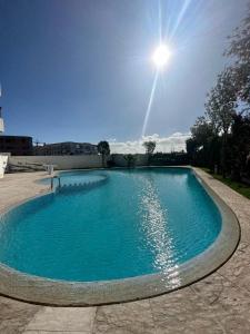a large swimming pool with the sun in the sky at Résidence Les Jardins Du Mazagan in El Jadida