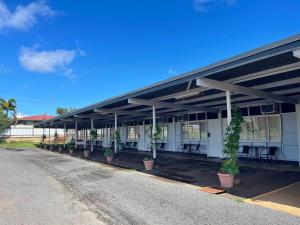 a building with a row of tables and potted plants at Sawmill Hotel Motel in Wondai
