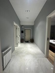 een lege hal met witte muren en een grote tegelvloer bij Apartment 5 in Doesjanbe
