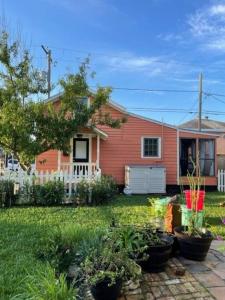 una casa roja con plantas en un patio en Kari's Island Escape - Historic District, en Galveston