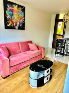 a living room with a pink couch and a table at Appartement moderne vieille ville PARKING GRATUIT in Annecy