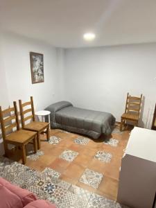 a bedroom with a bed and two chairs and a table at Alojamiento Rural VivoBosque in El Bosque