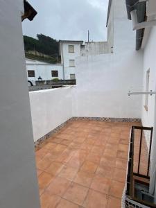 a balcony with a white wall and a tile floor at Alojamiento Rural VivoBosque in El Bosque