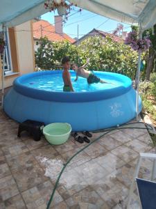 two children playing in a pool in a backyard at VillA SIMO in Kočani