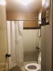 een kleine badkamer met een toilet en een douche bij Casa De Familia Staycation in Manilla