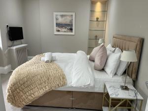 Central Park Hotel في لندن: غرفة نوم بسرير ذو شراشف ووسائد بيضاء
