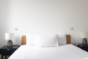 una camera con un letto bianco e 2 lampade di Lovely 1 Bedroom Apartment Holborn London a Londra