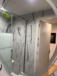 a mirror in a bathroom with a marble wall at Appartement moderne vieille ville PARKING GRATUIT in Annecy