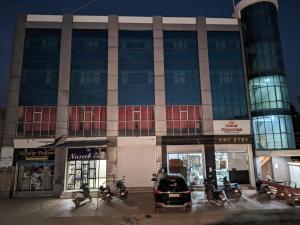 a building with cars parked in front of it at KRL Inn in Mandvi