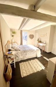 een slaapkamer met een bed en een raam bij Maison de Ville au centre historique d’Uzès in Uzès
