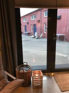 une fenêtre avec un panier et une vue sur un bâtiment dans l'établissement Verftet i Ny-Hellesund, à Søgne
