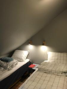 SøgneにあるVerftet i Ny-Hellesundのベッドルーム1室(ベッド2台付)、壁にランプが備わります。