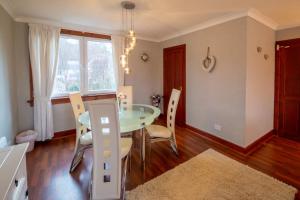 a dining room with a glass table and chairs at 2 wheelhouse apartments in Lochinver