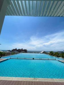 a large blue swimming pool with a roof at Novaworld Phan Thiết - Đông Phương Villa in Bình Tú
