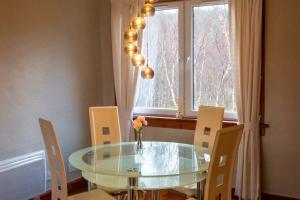 a dining room table with chairs and a vase with flowers at 2 wheelhouse apartments in Lochinver