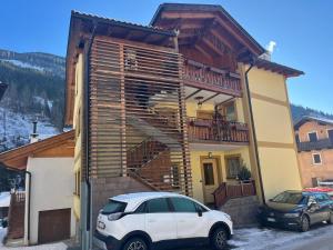 a white car parked in front of a house at Appartamenti Dolomiti in Moena