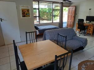 a living room with a table and a couch at Lemon Tree Cottage Noordhoek in Cape Town