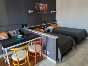 マルベーリャにあるApartamento en Puerto Banúsのベッド2台、テーブル、椅子が備わる客室です。