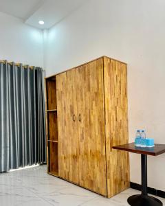 a wooden cabinet in a room with a table at BM guest house in Phnom Penh