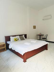 a bedroom with a large bed with white sheets at BM guest house in Phnom Penh