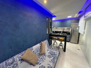 Apartamento no Centro de Nova Friburgo! في نوفا فريبورغو: كنب في مطبخ بجدار ازرق