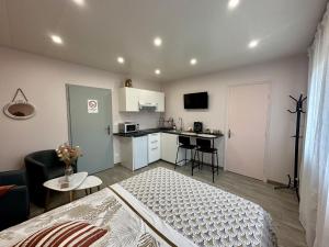ein kleines Zimmer mit einem Bett und einer Küche in der Unterkunft Studio Millésime in Nogent-lʼArtaud
