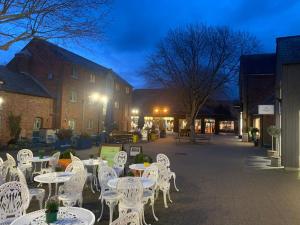a group of white tables and chairs on a street at Selfcatering Coach House New Forest Dog Friendly in Ringwood