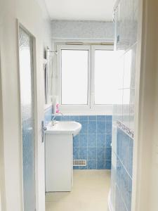 a bathroom with a sink and a window at Massy appart- 3 chambres intégralement équipé in Massy