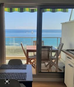cocina con mesa y vistas al océano en Happy 7, en Canet-en-Roussillon