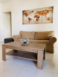 uma sala de estar com um sofá e uma mesa de café em madeira em Camelia Apartment em Nafplio